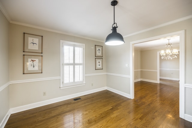 empty room featuring dark wood-type flooring, an inviting chandelier, and crown molding