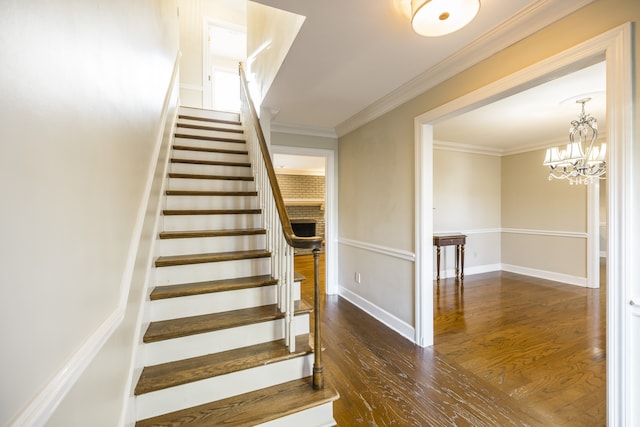 stairs featuring an inviting chandelier, crown molding, and hardwood / wood-style floors