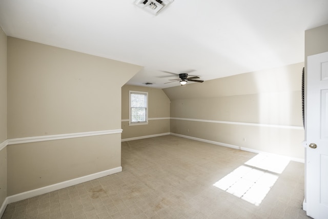 additional living space featuring ceiling fan, light colored carpet, and vaulted ceiling