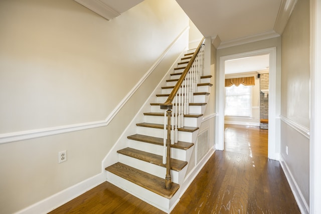 stairs with crown molding and hardwood / wood-style floors