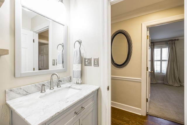 bathroom featuring ornamental molding, hardwood / wood-style floors, and vanity