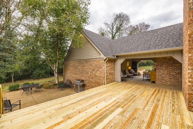 wooden deck featuring outdoor lounge area, a patio, and area for grilling