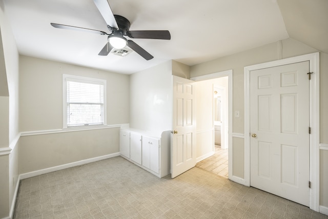 empty room featuring ceiling fan, light colored carpet, and lofted ceiling