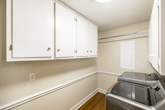 laundry area featuring dark wood-type flooring, cabinets, electric panel, and washer and dryer