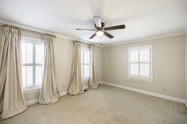 carpeted spare room featuring ceiling fan and crown molding