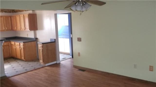 kitchen with ceiling fan and dark wood-type flooring