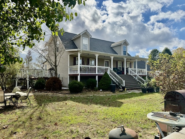 cape cod-style house featuring covered porch and a front yard