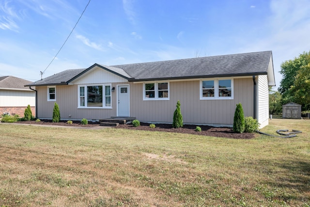 ranch-style home with a front yard and a shed