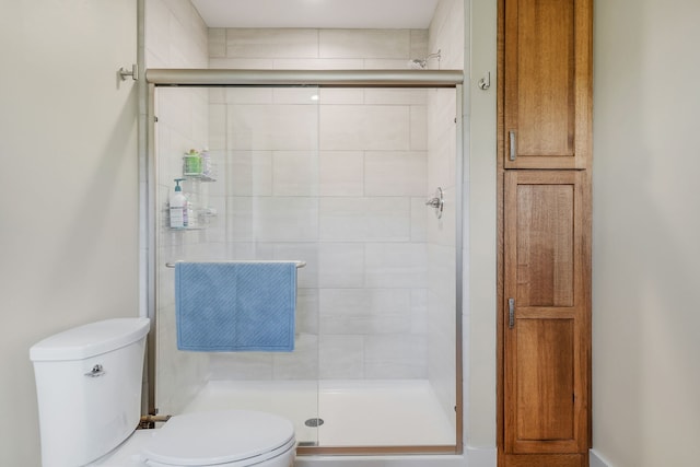 bathroom with toilet and a shower with door