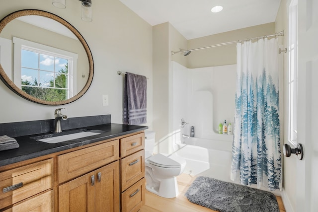 full bathroom featuring hardwood / wood-style flooring, vanity, toilet, and shower / bath combo with shower curtain