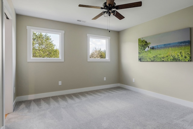 carpeted spare room with ceiling fan and a healthy amount of sunlight