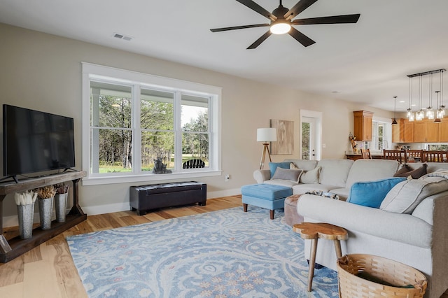 living room with light hardwood / wood-style floors and ceiling fan