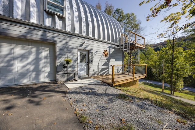 view of property exterior featuring a wooden deck and a garage