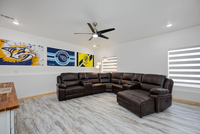 living room with light hardwood / wood-style flooring and ceiling fan