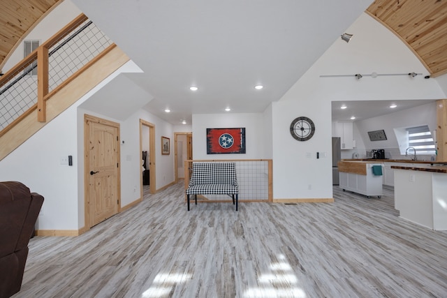 living room featuring a skylight, sink, and light hardwood / wood-style floors