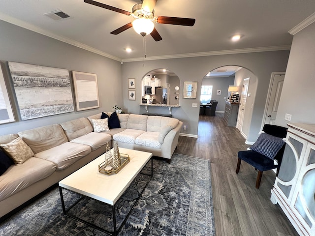 living room with ceiling fan, dark hardwood / wood-style floors, and ornamental molding