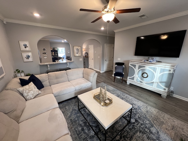 living room with ceiling fan, ornamental molding, and dark hardwood / wood-style flooring