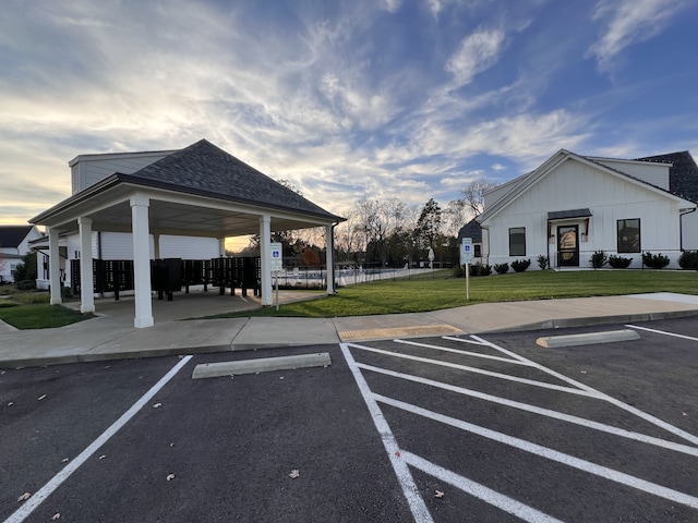 view of vehicle parking featuring mail boxes and a lawn