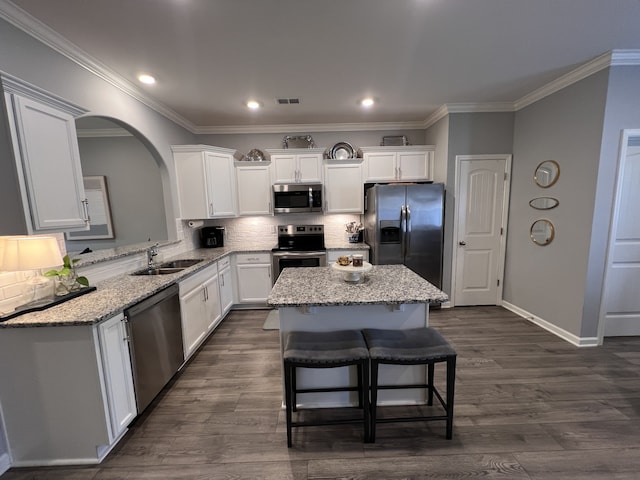 kitchen featuring a center island, sink, stainless steel appliances, dark hardwood / wood-style floors, and backsplash