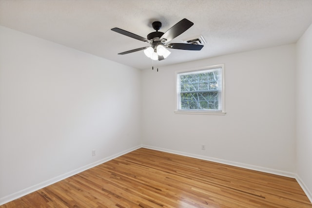 unfurnished room featuring ceiling fan, light wood-type flooring, and a textured ceiling