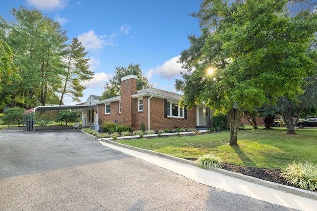 view of front of house with a carport and a front yard