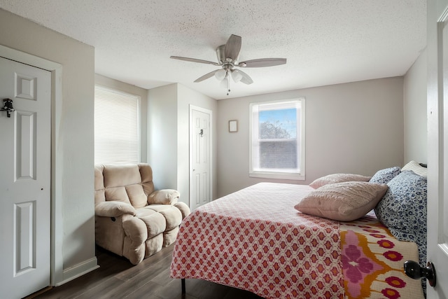 bedroom with ceiling fan, dark wood-type flooring, and a textured ceiling