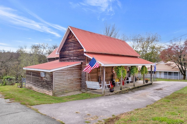 exterior space featuring a wall mounted air conditioner and covered porch