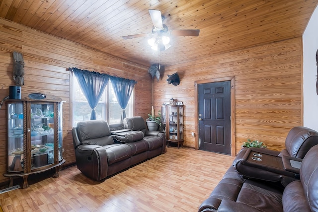 living room with ceiling fan, wood walls, wood-type flooring, and wooden ceiling