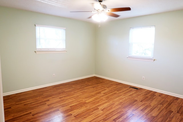 unfurnished room featuring hardwood / wood-style flooring, ceiling fan, and a wealth of natural light