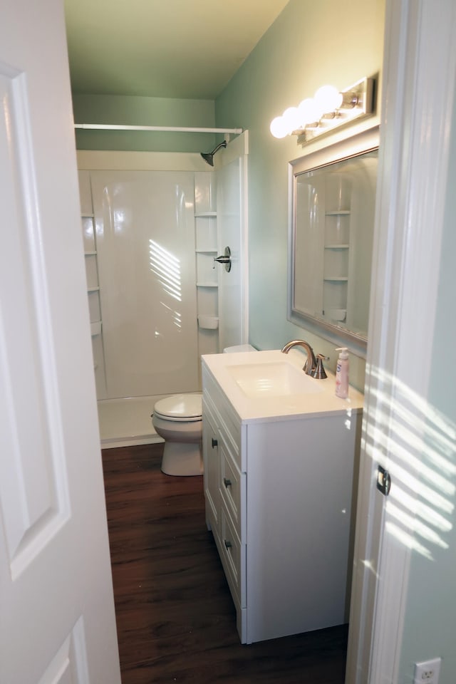 bathroom with vanity, toilet, a shower, and wood-type flooring