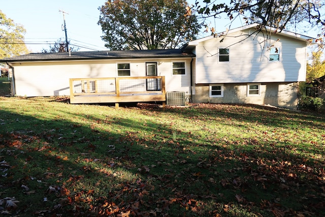 rear view of property featuring a deck, cooling unit, and a lawn