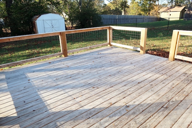 wooden terrace featuring a storage shed and a yard