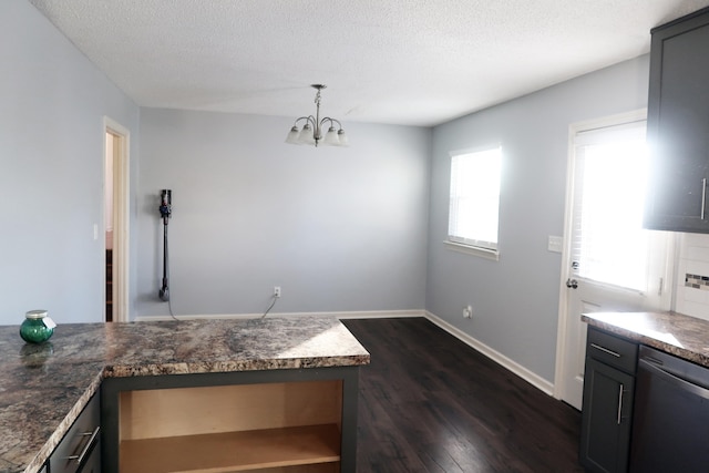 kitchen featuring pendant lighting, stainless steel dishwasher, dark stone countertops, a textured ceiling, and dark hardwood / wood-style flooring