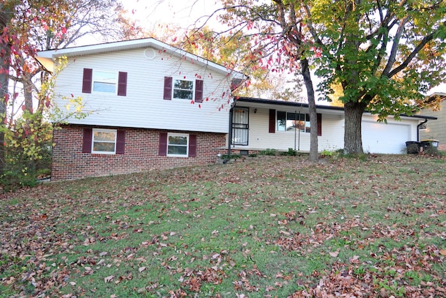 split level home with covered porch, a garage, and a front lawn