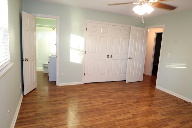 unfurnished bedroom featuring dark hardwood / wood-style floors, ceiling fan, and a closet