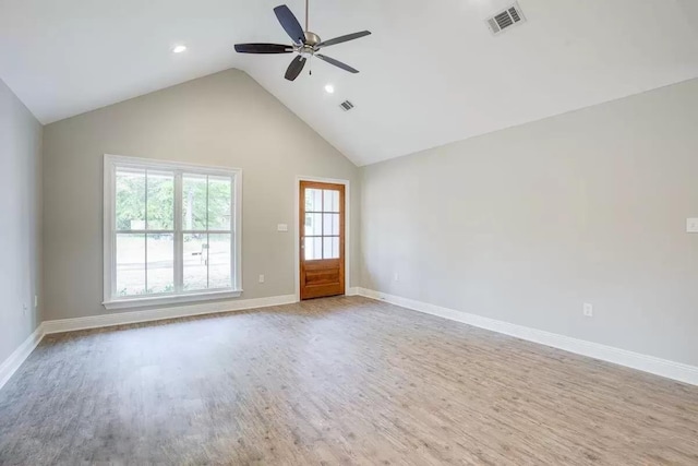 empty room with light wood-type flooring, high vaulted ceiling, and ceiling fan