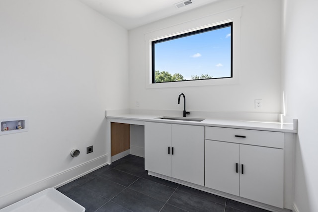 washroom featuring electric dryer hookup, cabinets, sink, washer hookup, and dark tile patterned floors