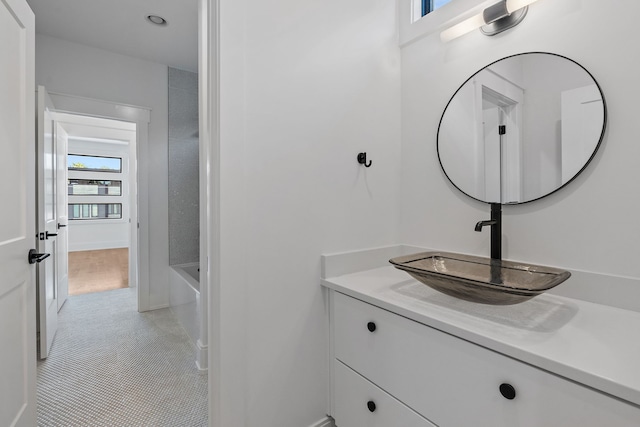 bathroom featuring tile patterned floors, vanity, and a washtub