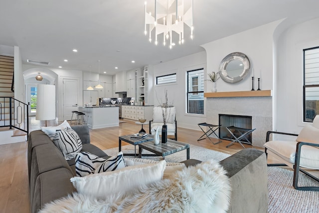 living room with light wood-type flooring and a chandelier