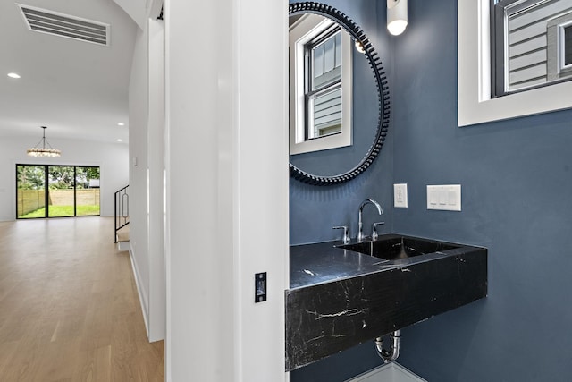 bathroom featuring hardwood / wood-style floors, sink, and a chandelier