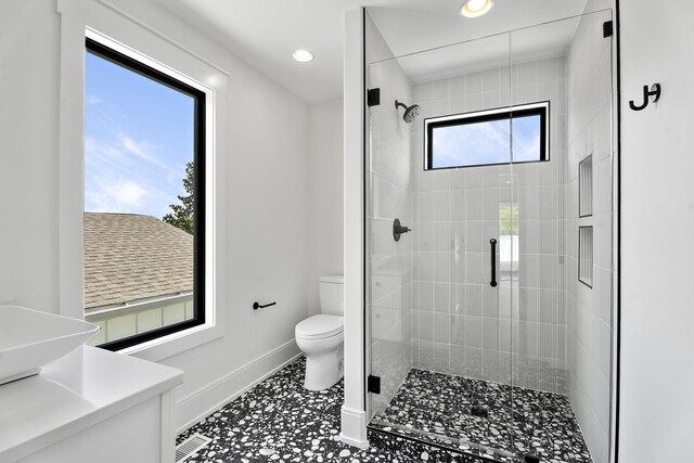 bathroom with a shower with door, vanity, and toilet