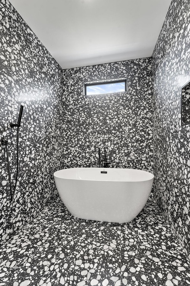 bathroom with tile walls and a tub to relax in