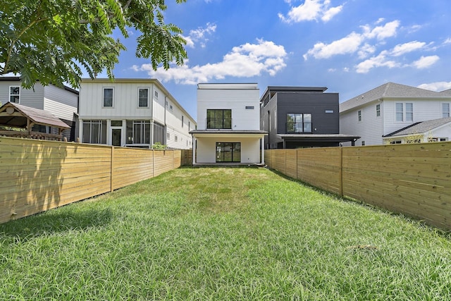 rear view of property featuring a yard