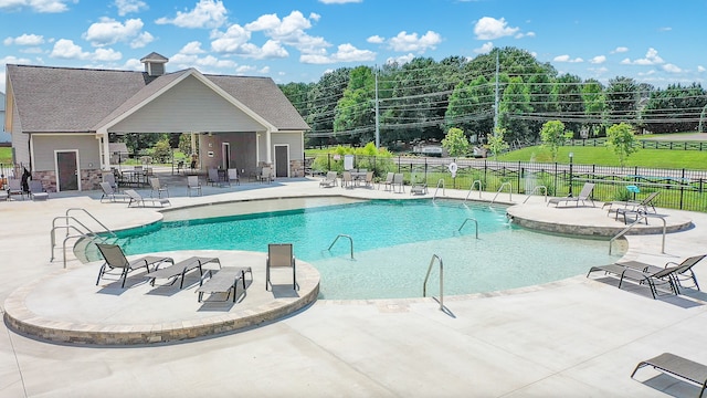 view of swimming pool featuring ceiling fan and a patio area