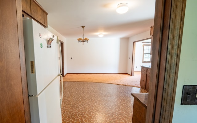 kitchen featuring a chandelier, decorative light fixtures, and white fridge