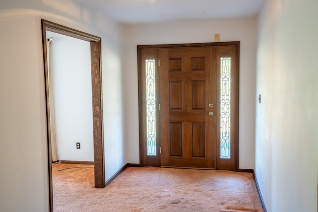 entrance foyer with light colored carpet and a healthy amount of sunlight