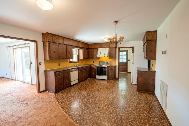 kitchen featuring white appliances, sink, exhaust hood, and an inviting chandelier