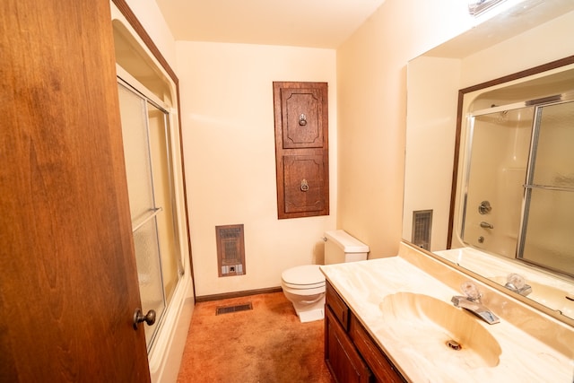 bathroom with heating unit, vanity, and combined bath / shower with glass door