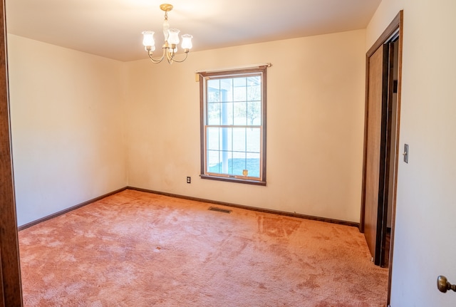 unfurnished room featuring light colored carpet and a chandelier