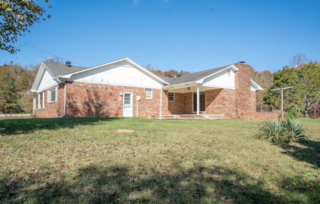 rear view of house featuring a yard